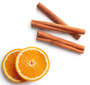 Three cinnamon sticks arranged diagonally above two sliced orange halves on a clean white background.