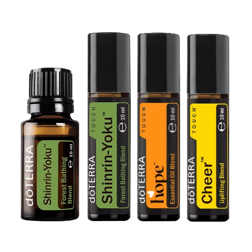 Four doTERRA essential oil products on a white background: a Shinrin-Yoku Forest Bathing Blend bottle, a Shinrin-Yoku Touch roll-on, a Hope Essential Oil Blend roll-on, and a Cheer uplifting blend roll-on.