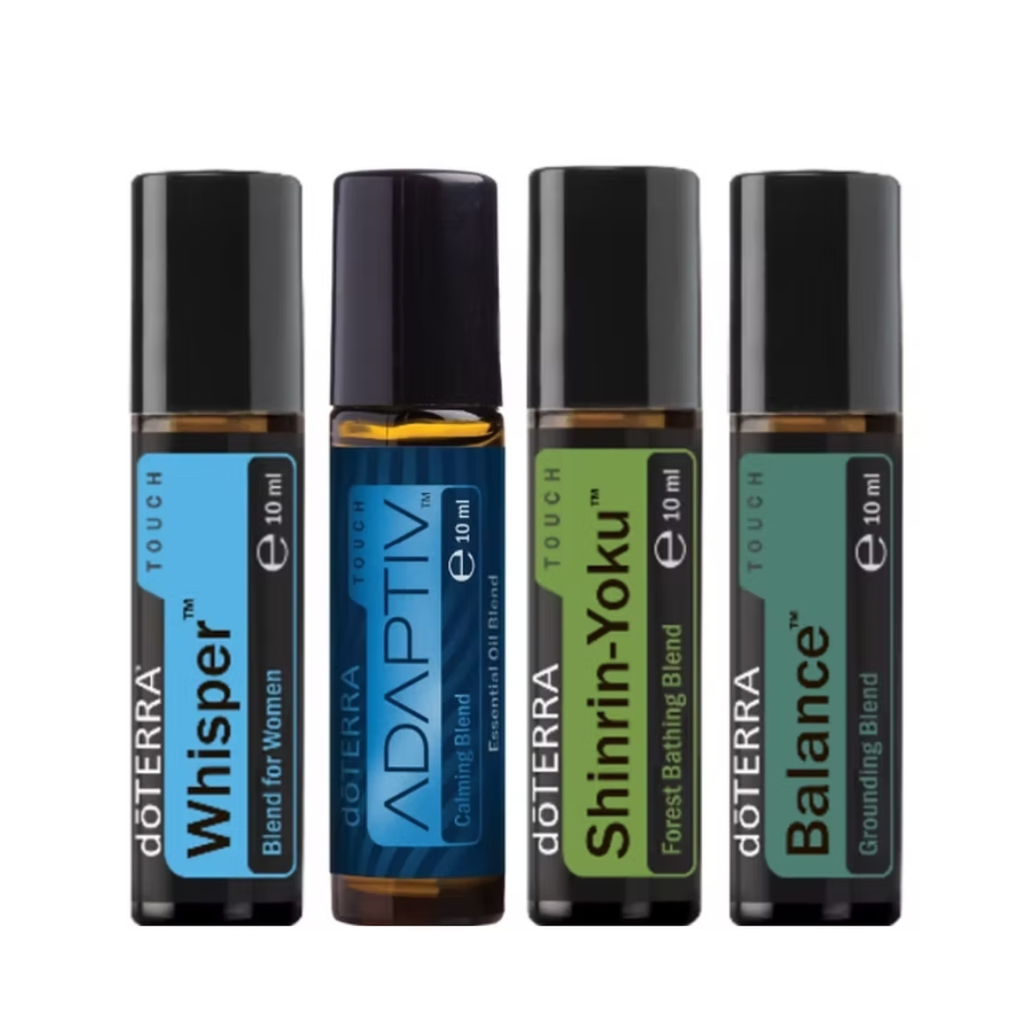 Four döTERRA Touch essential oil blend roller bottles arranged side by side on a white background. The bottles are Whisper, Adaptiv, Shinrin-Yoku, and Balance, each with a black cap and a colored label (blue, dark blue, green, and teal) indicating different blends.
