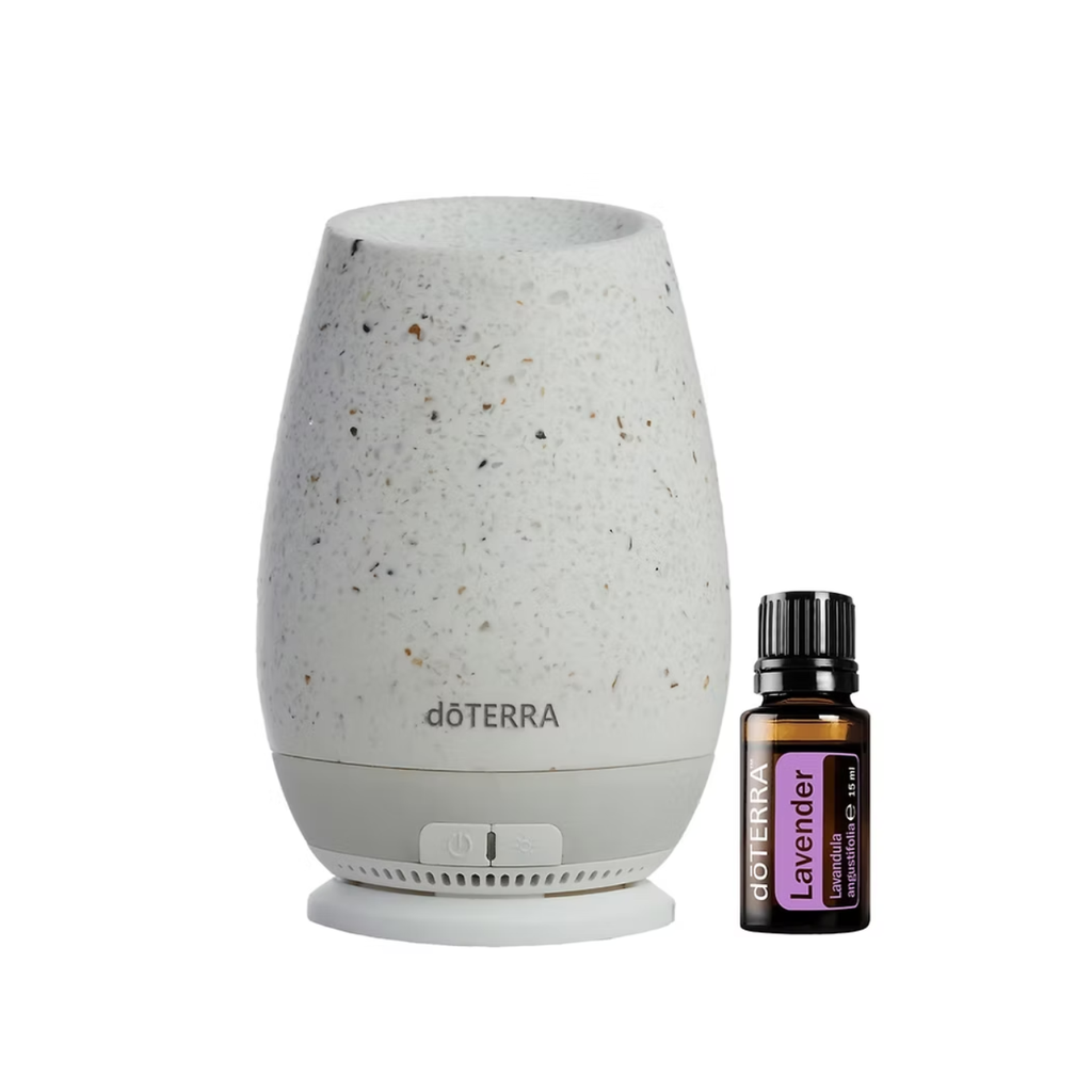 A döTERRA essential oil diffuser lamp in a speckled off-white ceramic finish, shown next to a small bottle of döTERRA Lavender essential oil on a plain white background.