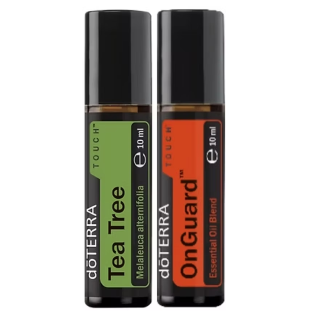 Two 10 ml doTERRA essential oil roller bottles standing side by side on a plain white background. The left bottle is labeled Tea Tree with a green label, and the right bottle is labeled OnGuard with an orange label.