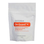 A white stand-up pouch of doTERRA On Guard + food supplement with sweeteners, featuring a prominent orange label and gray text, on a plain white background.